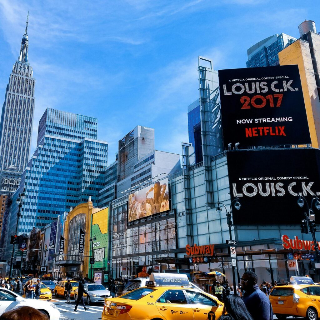 A vibrant scene featuring New York City's skyscrapers and taxis under a bright blue sky.