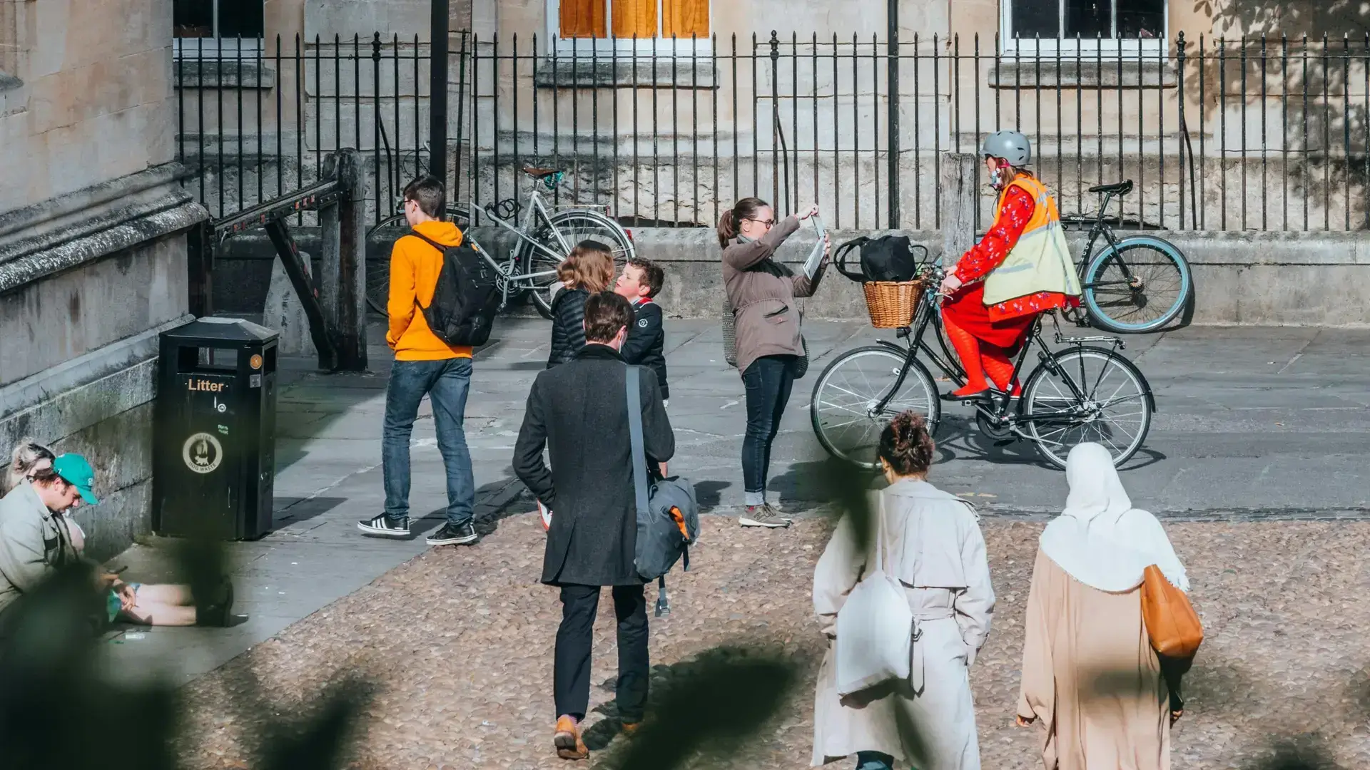 A vibrant street scene in Oxford with people walking and cycling.