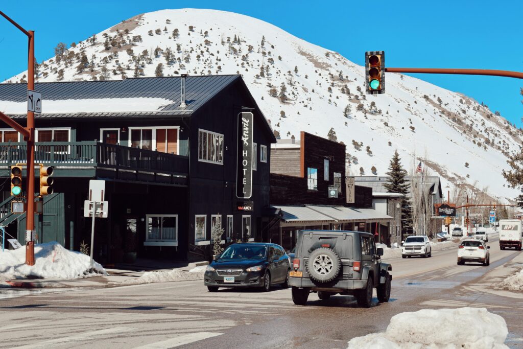Charming winter day in Jackson, WY showcasing snow-covered streets, hotel, and mountains.