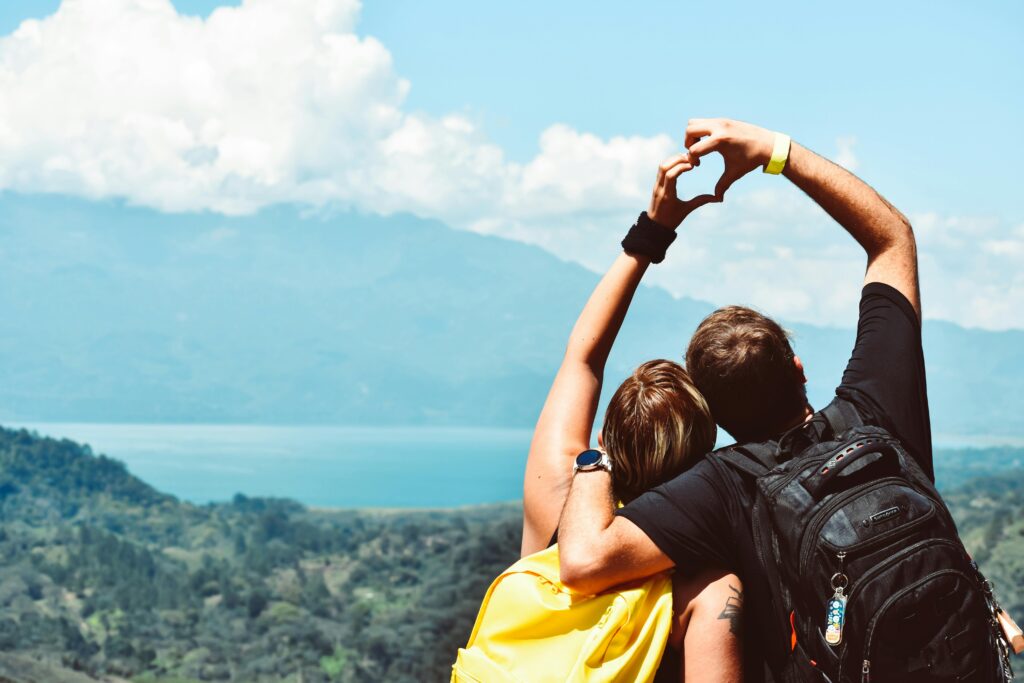Couple making a heart shape with arms over a beautiful view in Honduras.