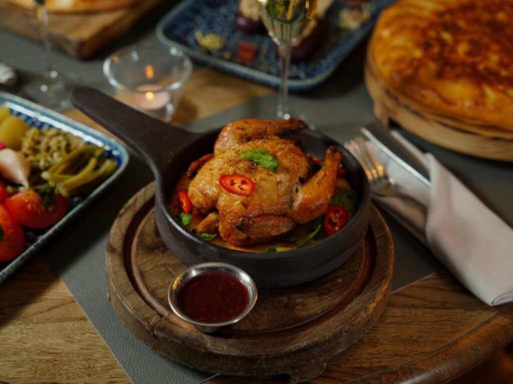 Savor a gourmet roast chicken dish with pepper garnishes in an elegant dining setting.
