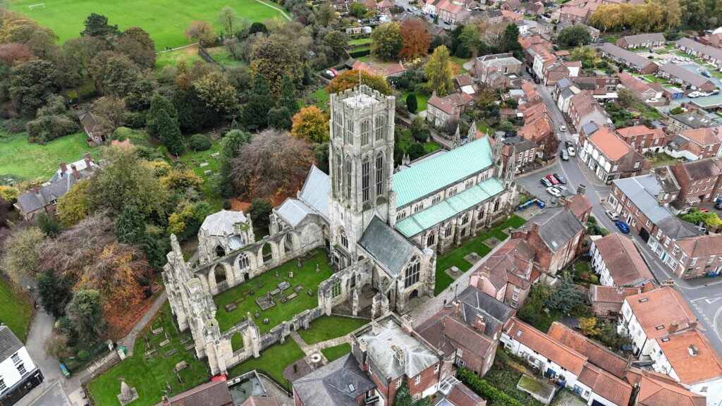 Stunning aerial shot of Howden Minster surrounded by autumn foliage in England.