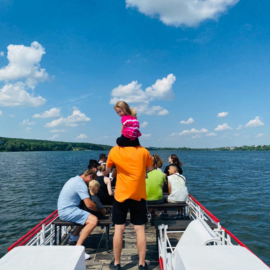Family group enjoying a scenic boat ride on a sunny day, perfect outdoor relaxation.