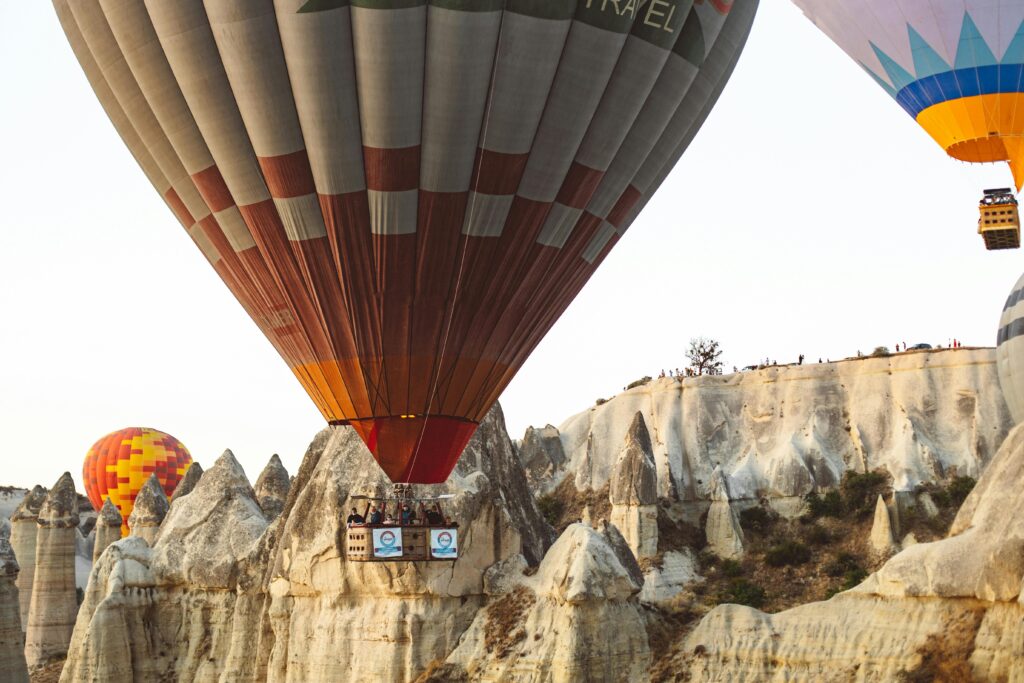 Hot air balloons soar over the unique rock formations of Cappadocia at sunset.