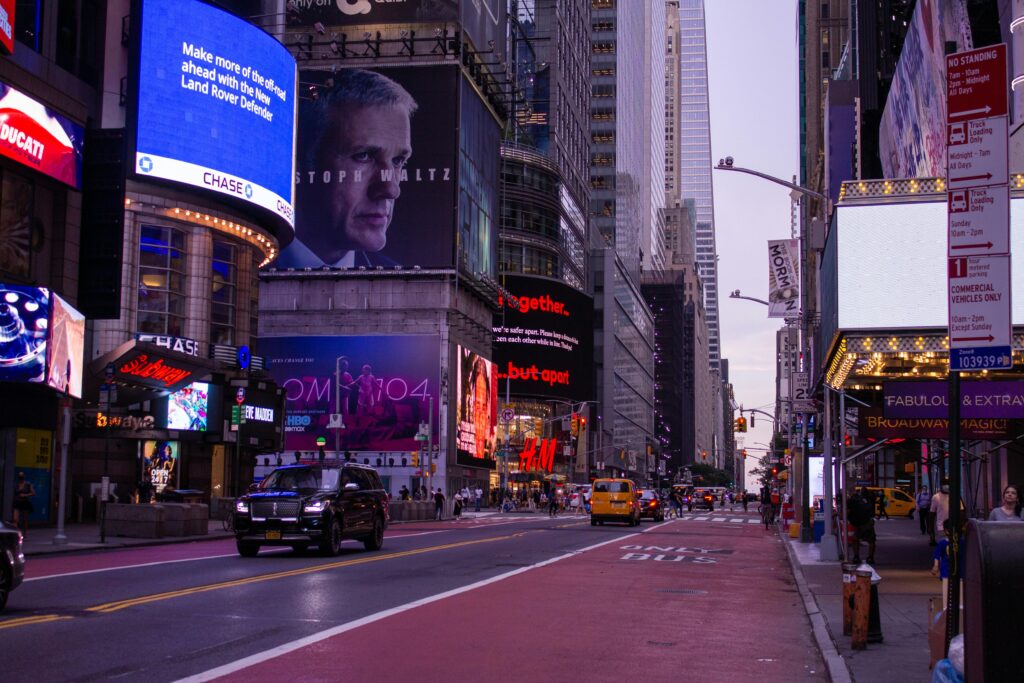 Illuminated Times Square in New York City featuring bright billboards and bustling street traffic at night.