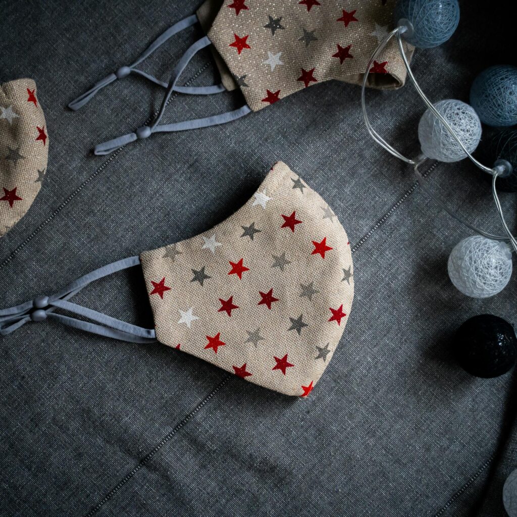 Close-up of star-patterned face masks on gray fabric, perfect for festive or everyday protection.