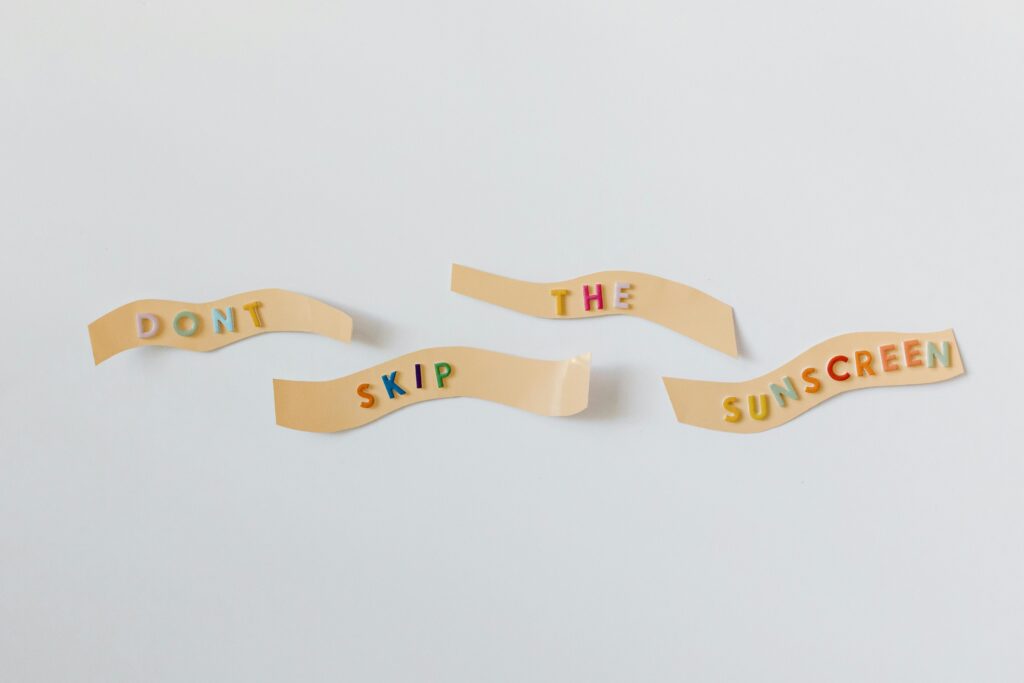 Colorful reminder to apply sunscreen with text on bandages on a white background.