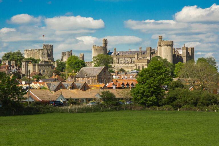 Beautiful landscape view of Arundel Castle with the town below, under a clear blue sky.