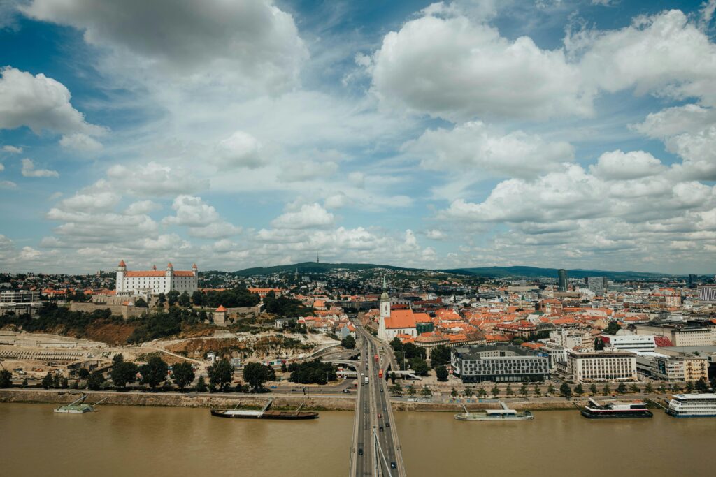 A breathtaking aerial shot of Bratislava's city skyline featuring the Danube River and iconic landmarks.