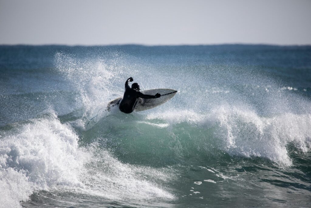 Surfer performing a daring maneuver on coastal waves in Yangyang, South Korea.