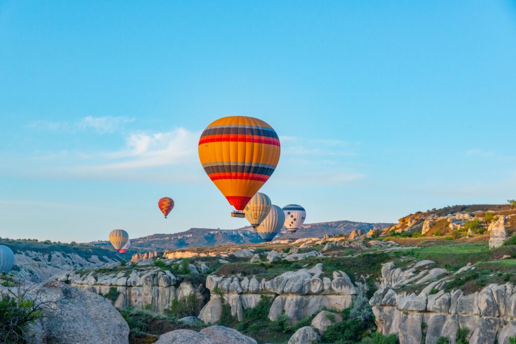Colorful hot air balloons float above Cappadocia's unique rock formations at dawn.