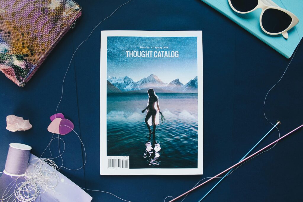 Creative flat lay featuring a Thought Catalog magazine with colorful threads and accessories.