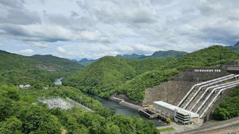 A stunning landscape of Srinagarind Dam and lush hills in Kanchanaburi, Thailand.