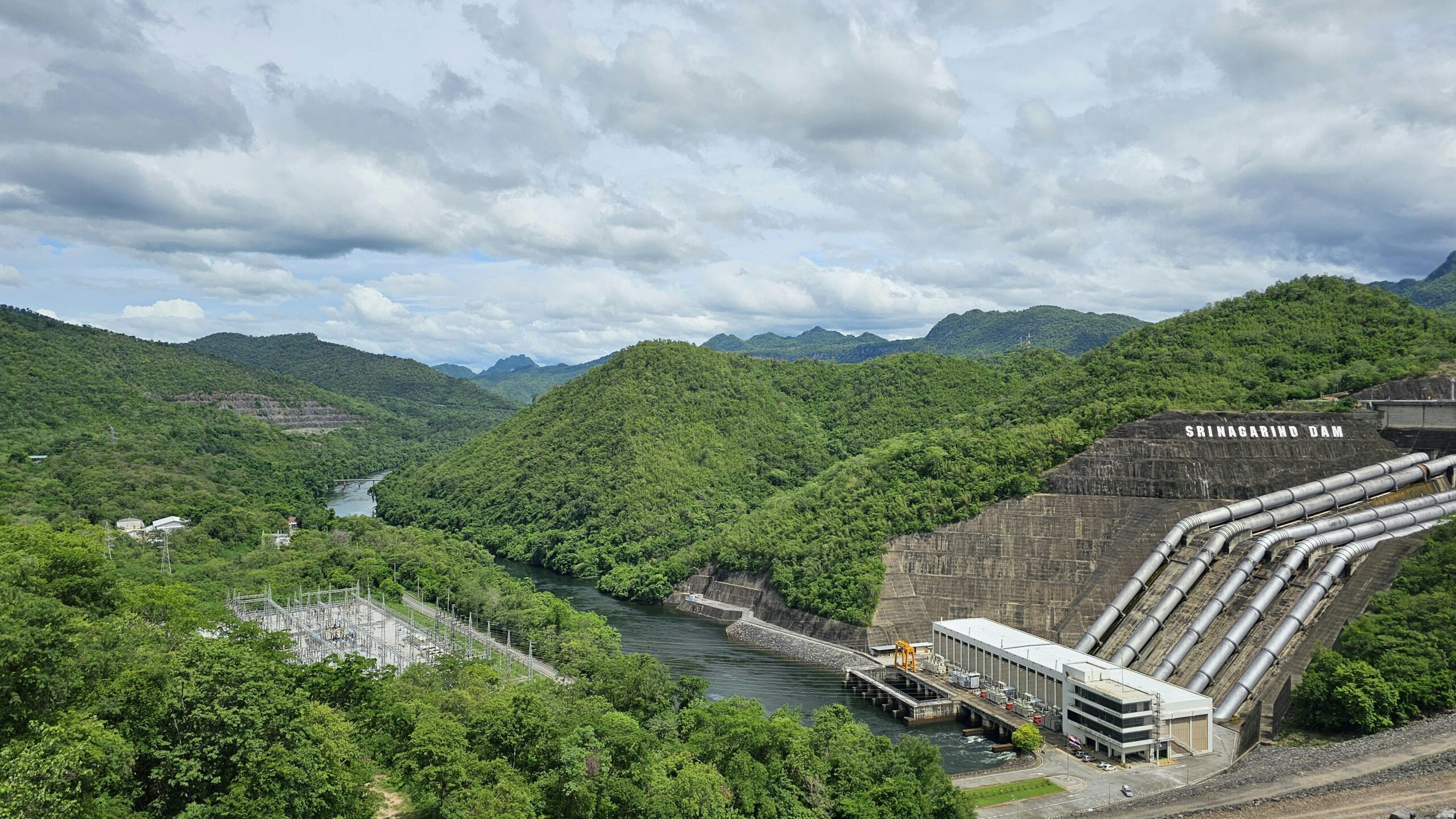 A stunning landscape of Srinagarind Dam and lush hills in Kanchanaburi, Thailand.