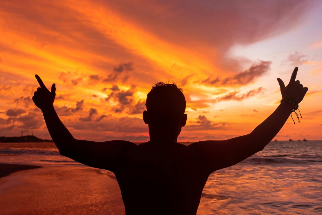 Silhouette of a person enjoying a vibrant sunset on the beach in Lima, Perú.