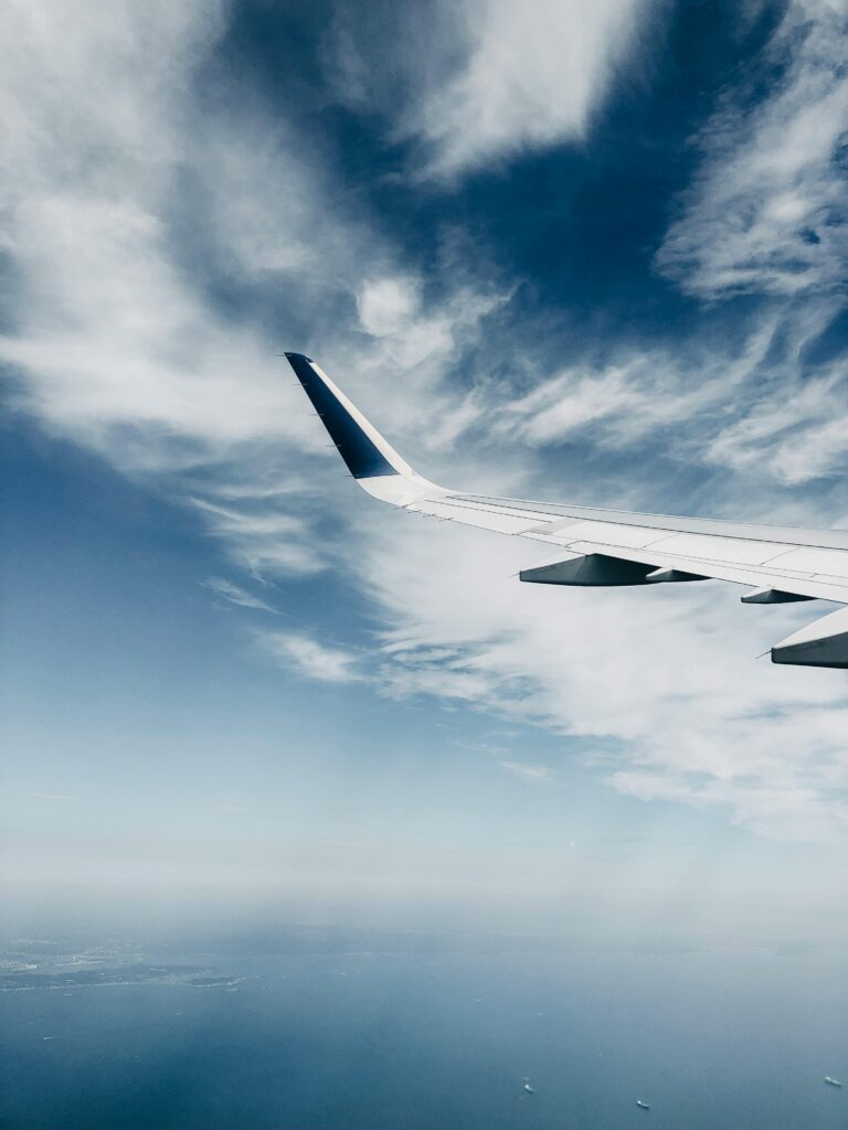 A scenic view of an airplane wing cruising above the clouds, capturing the serene sky.