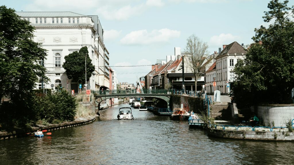 Charming view of a canal with boats and historic buildings in a European city under a clear sky.
