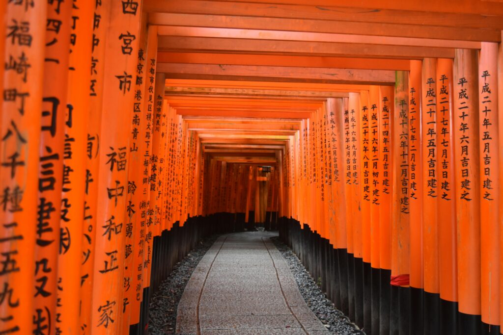 Vibrant torii gates at Fushimi Inari Taisha, Kyoto, Japan, showcasing traditional Japanese architecture.