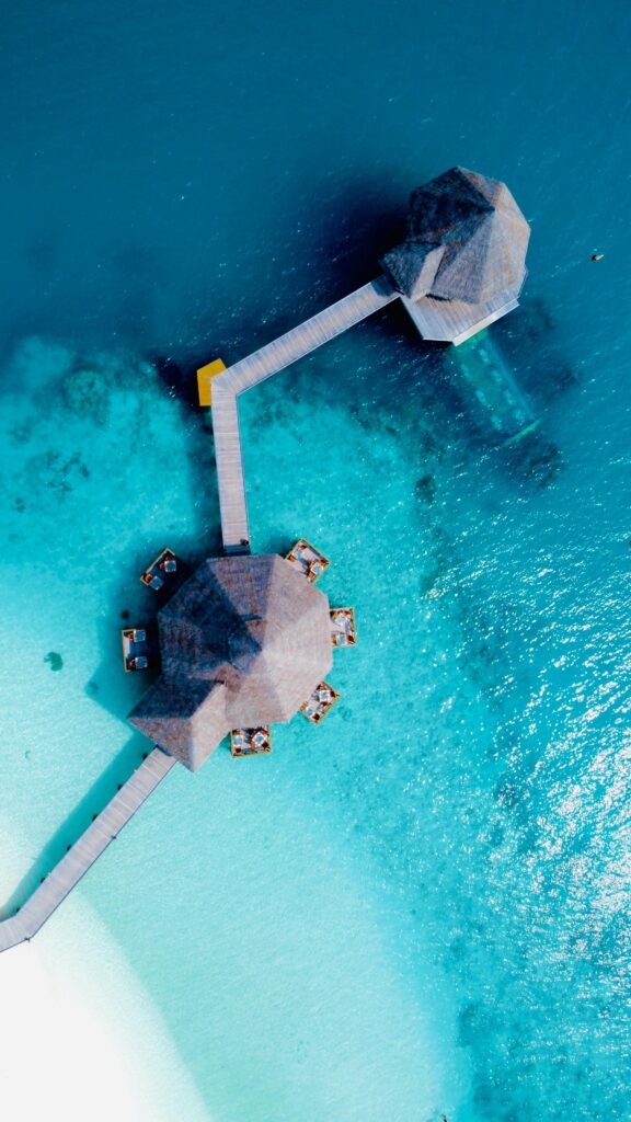 A stunning aerial view of overwater villas in the Maldives amidst turquoise waters.